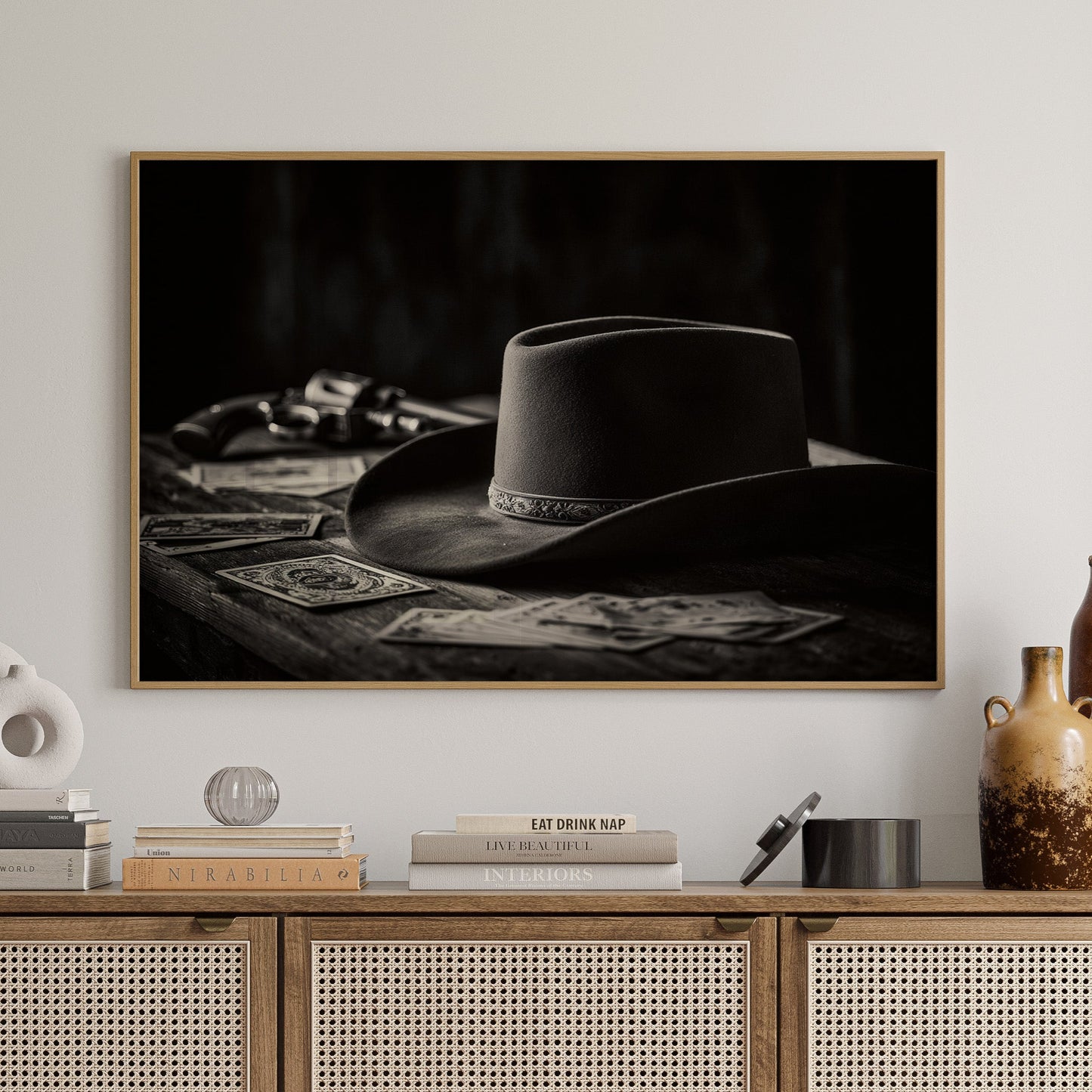 Wooden cabinet with decorative items and a framed black and white photo of a cowboy hat on a wall.