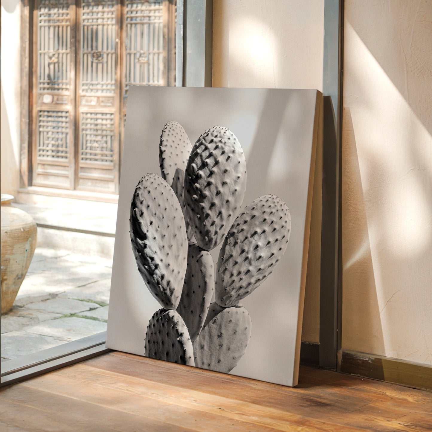 Decorative painting of a cactus on a wooden floor with a glass door in the background