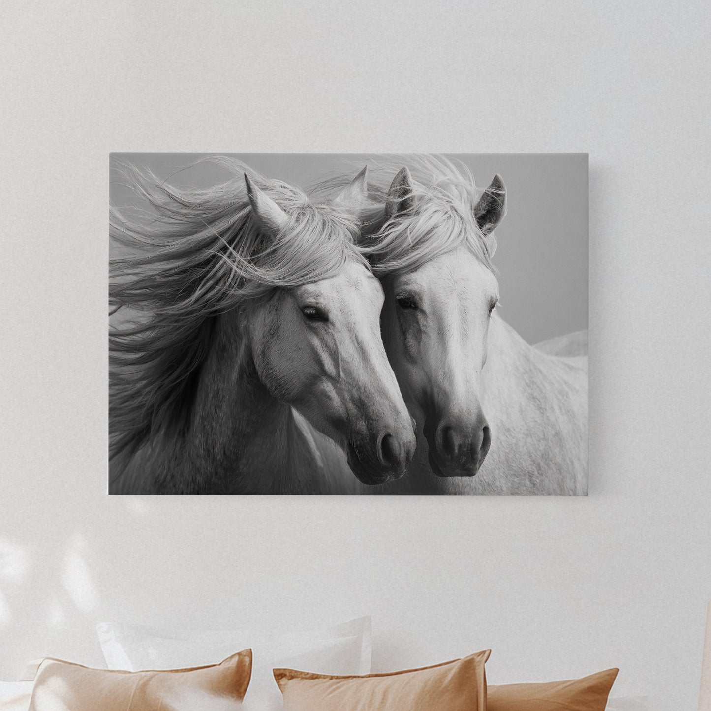 Canvas print of two horses on a wall above a bed with pillows and a lamp.