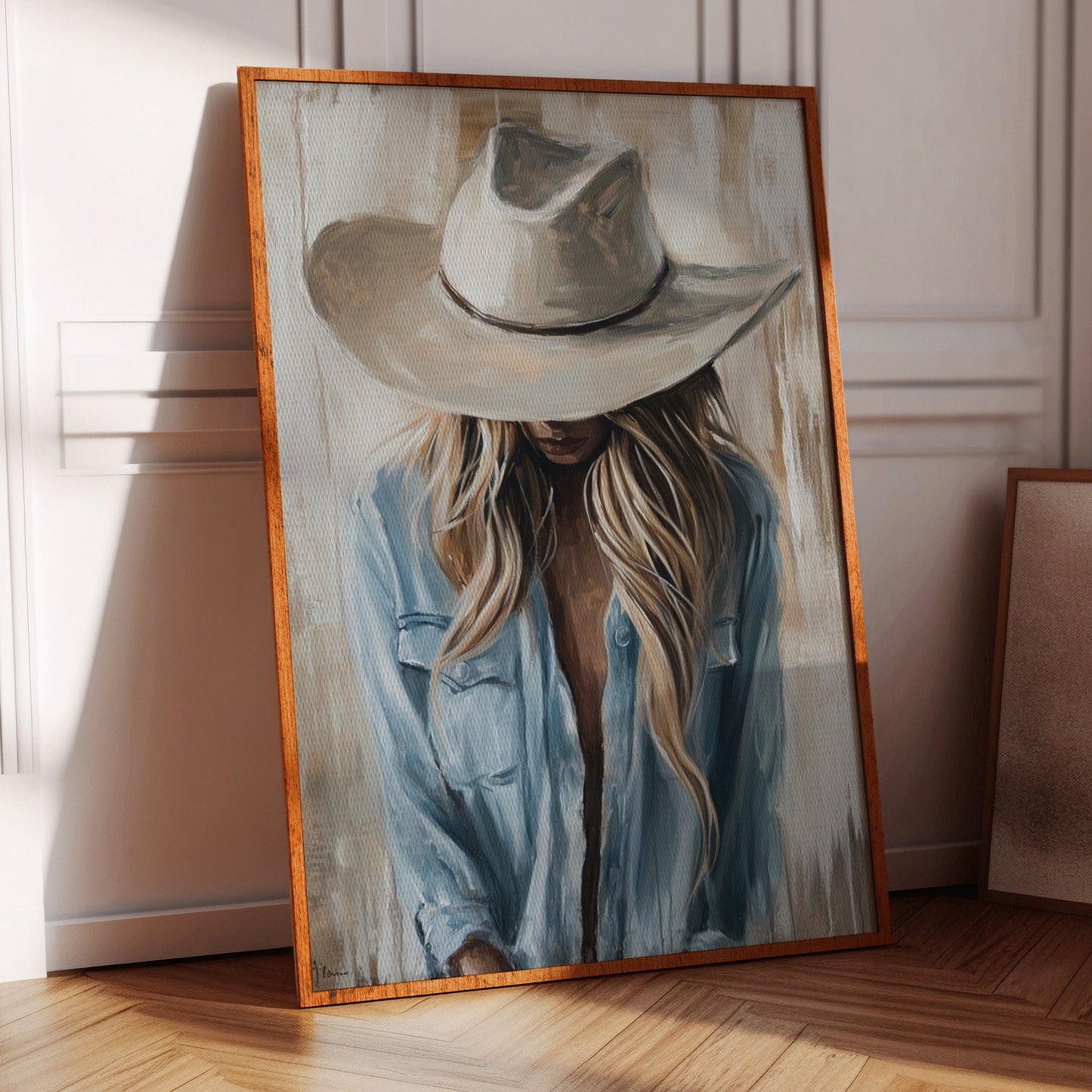 Framed painting of a person wearing a cowboy hat in a room with wooden floor and chair.