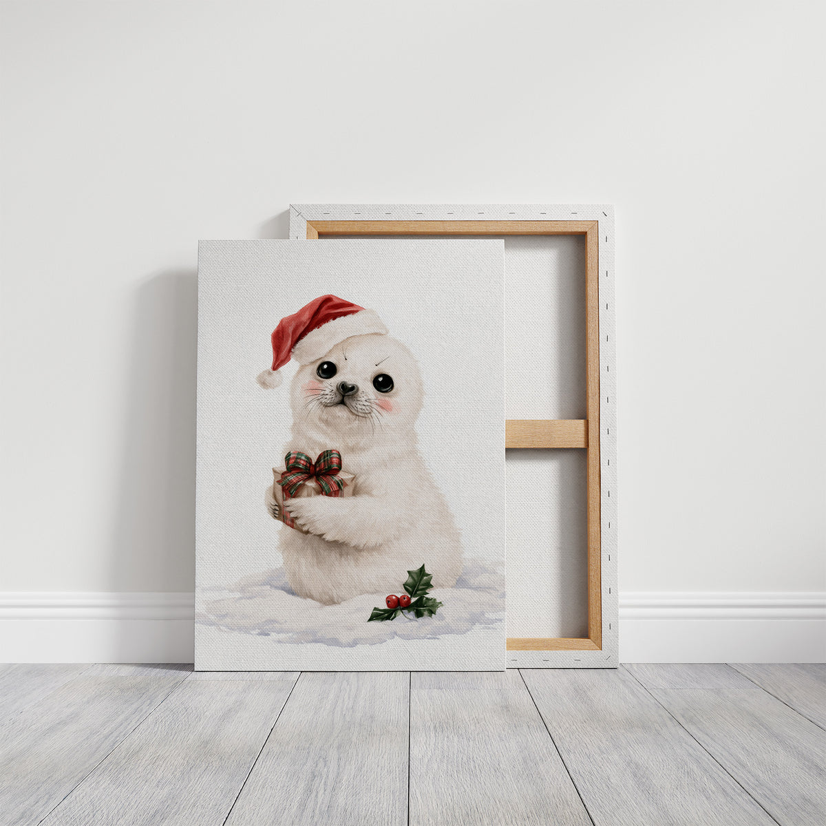 A Snowy Pup Waits for Morning, a white baby seal in a red Santa hat holding a chocolate bow, with a sprig of holly in the snow below, painted in soft cream, red and white, on a gallery canvas with wrapped edges leaning against a white wall