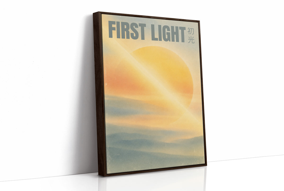 First Light Over a Quiet Sea, a pale sunrise over a soft sea, a warm yellow sun glowing above a band of blue water and peach clouds, with the words FIRST LIGHT in gray capitals across the top and a small Japanese word beside them, as a framed canvas in a brown frame