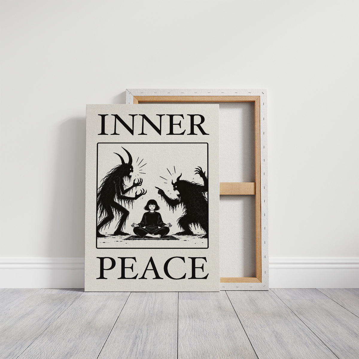 Inner Peace Has Company, two horned shadow figures in black flanking a small seated figure meditating at the base, cream ground in a black serif frame, with INNER above and PEACE below, on a gallery canvas with wrapped edges leaning against a white wall