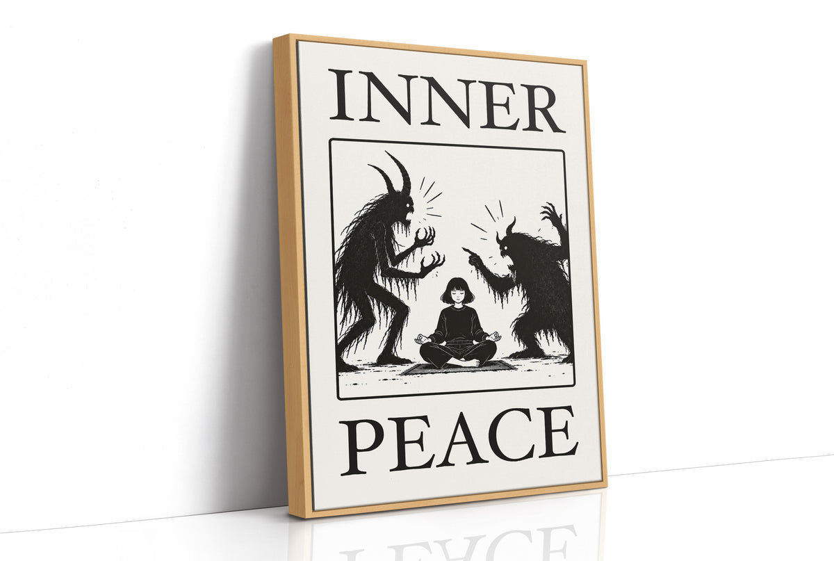 Inner Peace Has Company, two horned shadow figures in black flanking a small seated figure meditating at the base, cream ground in a black serif frame, with INNER above and PEACE below, as a framed canvas in a natural wood frame