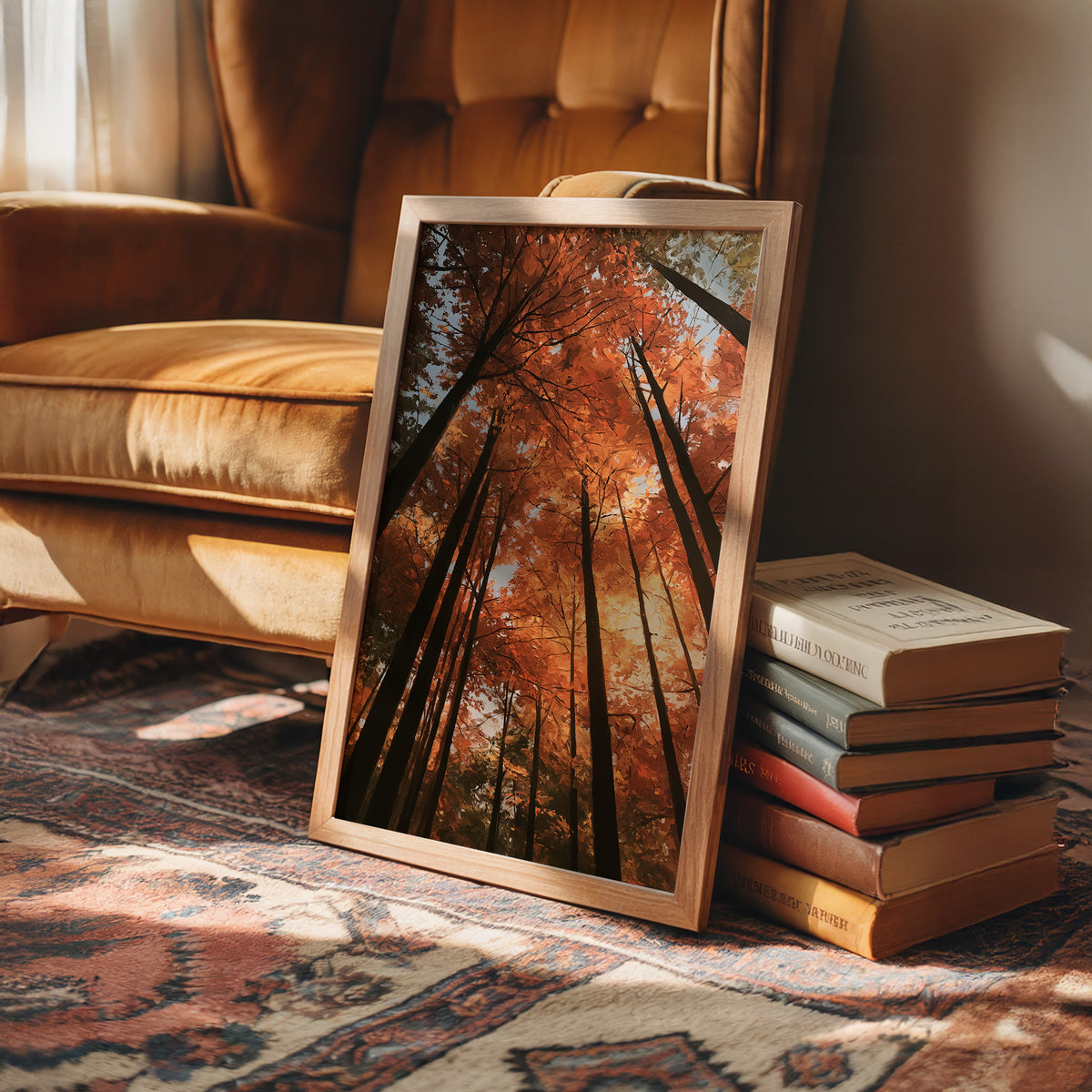 Look Up Into the Burning Wood, looking straight up through a canopy of tall dark trunks and orange autumn foliage, the pale sky glowing behind them, painted in rust, burnt orange and charcoal, in a wood frame on a rug beside a leather armchair and a stack of books