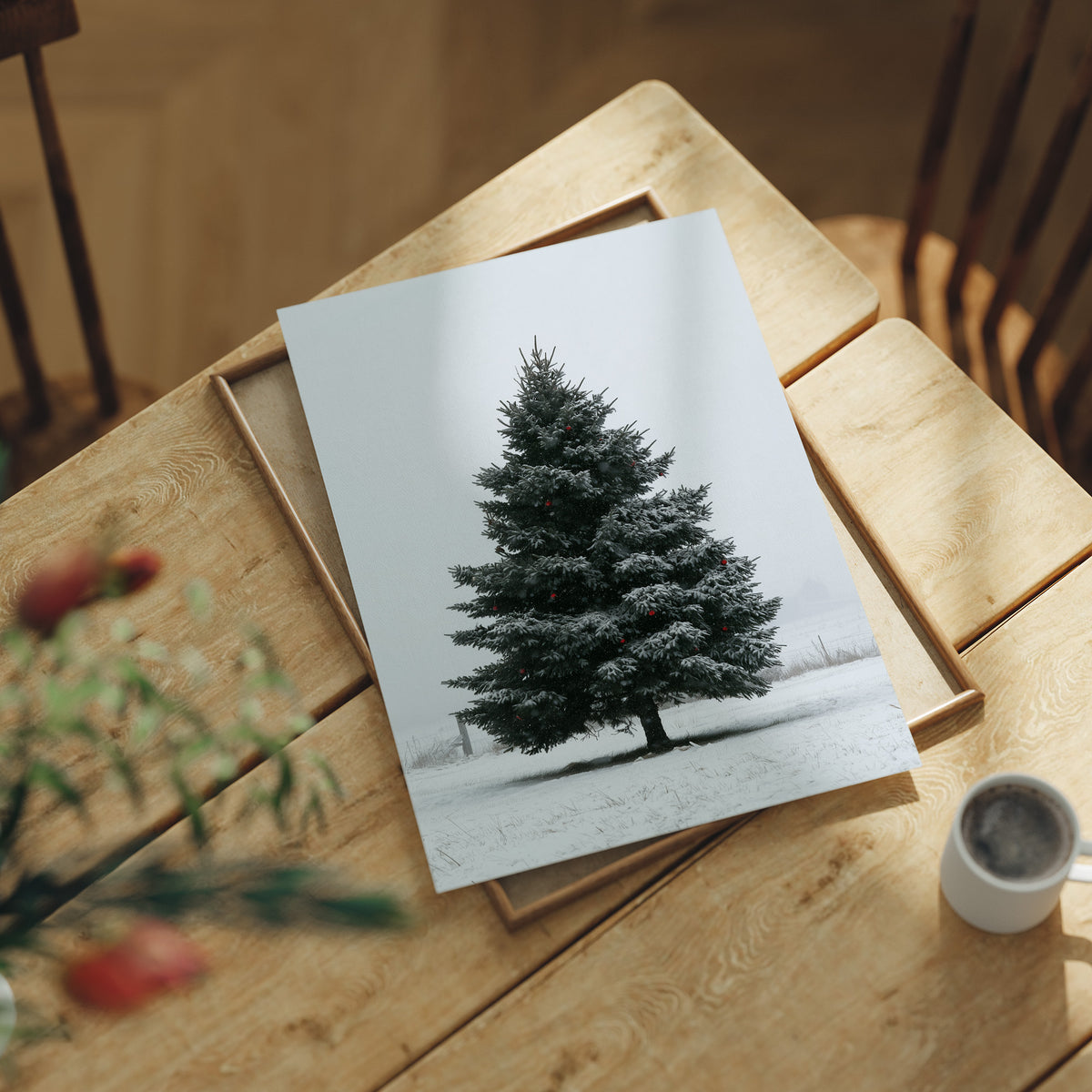 One Spruce Holds the Snowfield, a single dark spruce standing alone in a snowy field under a pale gray sky, painted in forest green, snow white and soft gray, lying flat on a light wood table beside a coffee cup and red berries