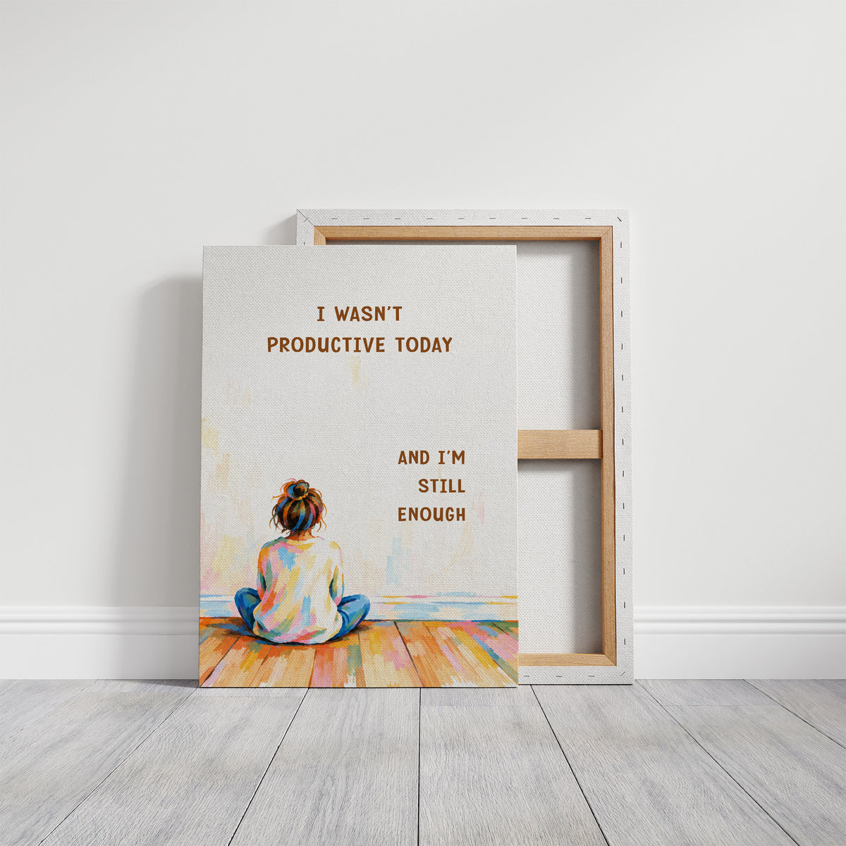 Quiet Hours on Painted Floors, a child seen from behind sitting cross legged on painted floorboards in coral, blue and cream, with two lines of bold brown lettering on a pale cream ground, in a soft illustrated style, on a gallery canvas with wrapped edges leaning against a white wall