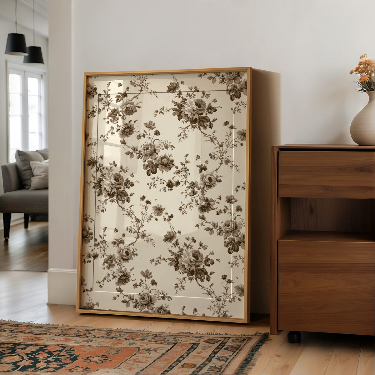 Roses Keep to the Linen, a repeating vintage pattern of brown roses and leafy sprigs on a cream ground, in a wood frame on a wall beside a walnut cabinet and an open doorway