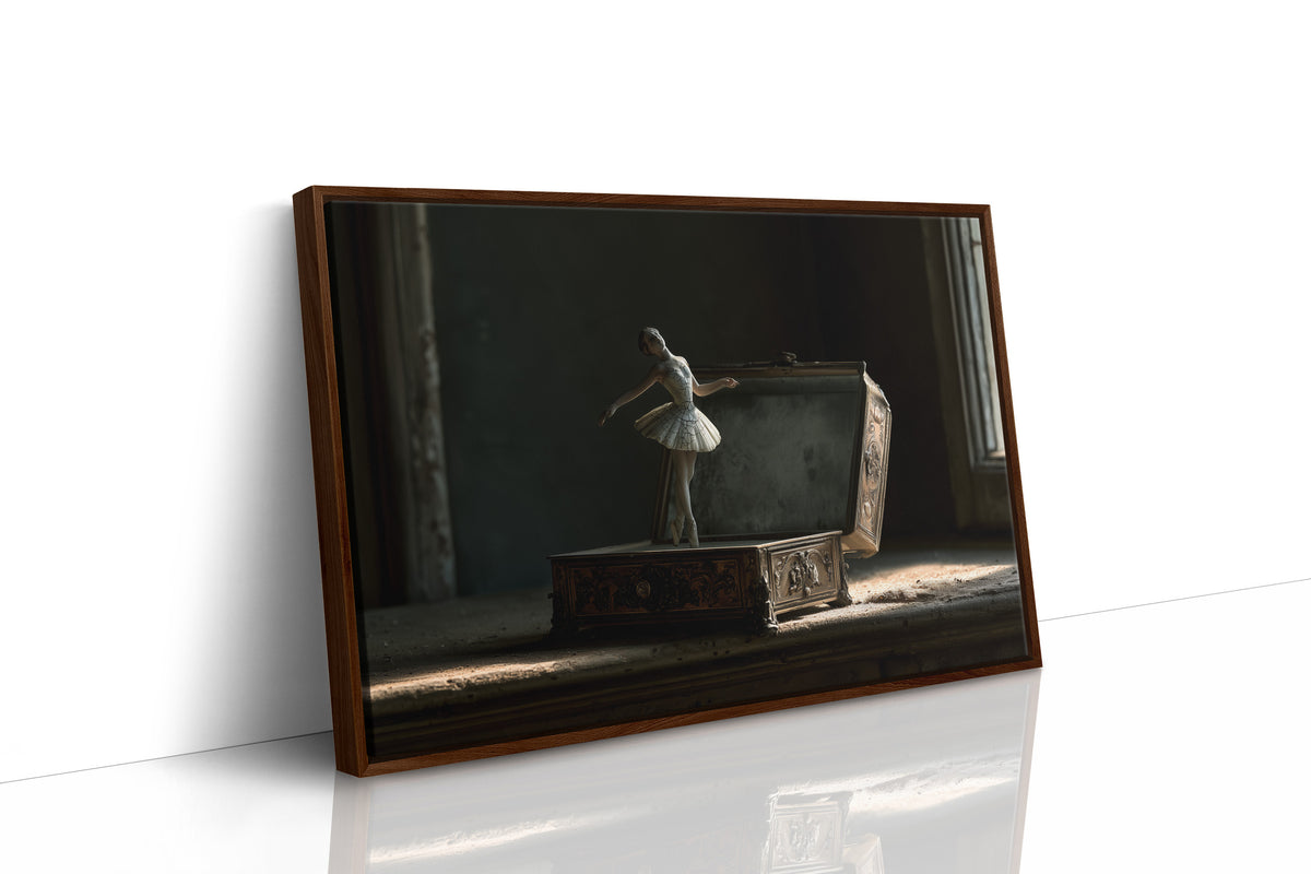She Waits Before the First Note, a porcelain ballerina figurine poised on a carved music box in a dim room, painted in charcoal, slate and pale ivory, as a framed canvas in a brown frame