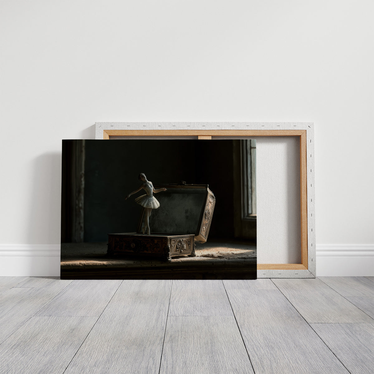 She Waits Before the First Note, a porcelain ballerina figurine poised on a carved music box in a dim room, painted in charcoal, slate and pale ivory, on a gallery canvas with wrapped edges leaning against a white wall