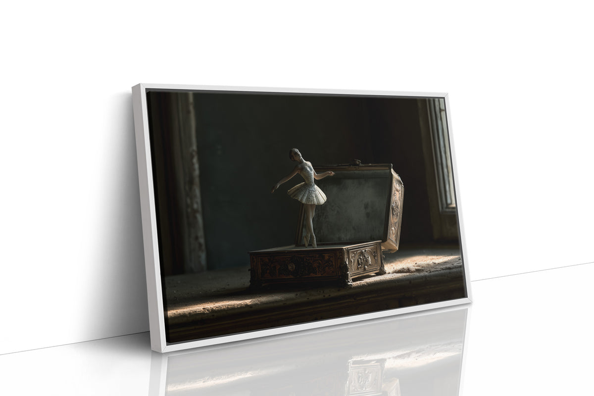 She Waits Before the First Note, a porcelain ballerina figurine poised on a carved music box in a dim room, painted in charcoal, slate and pale ivory, as a framed canvas in a white frame