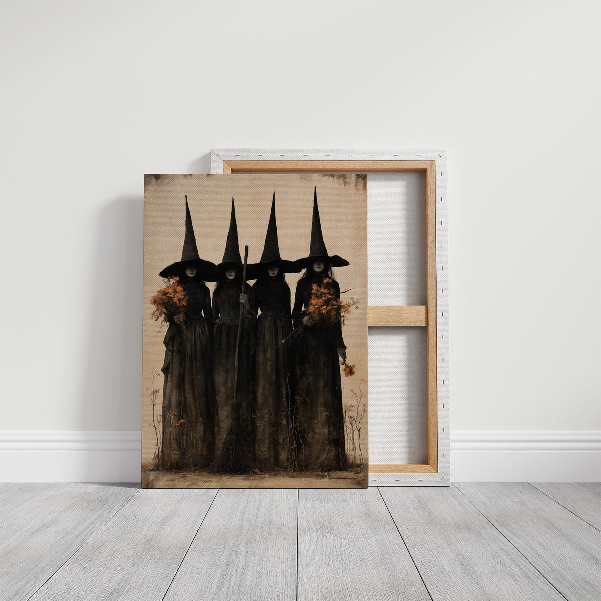 The Coven Keeps Its Silence, five witches in tall pointed hats standing shoulder to shoulder, painted in black, charcoal and dusty cream, on a gallery canvas with wrapped edges leaning against a white wall