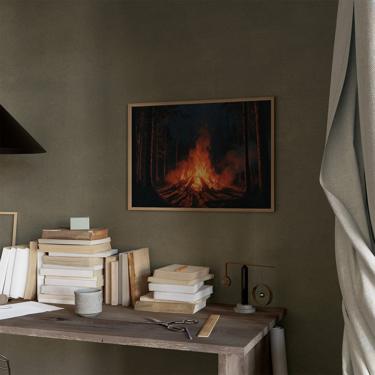 The Fire Keeps Its Own Counsel, campfire blazing in a dark pine forest painting, in a thin wood frame on a moss green wall above a desk stacked with books