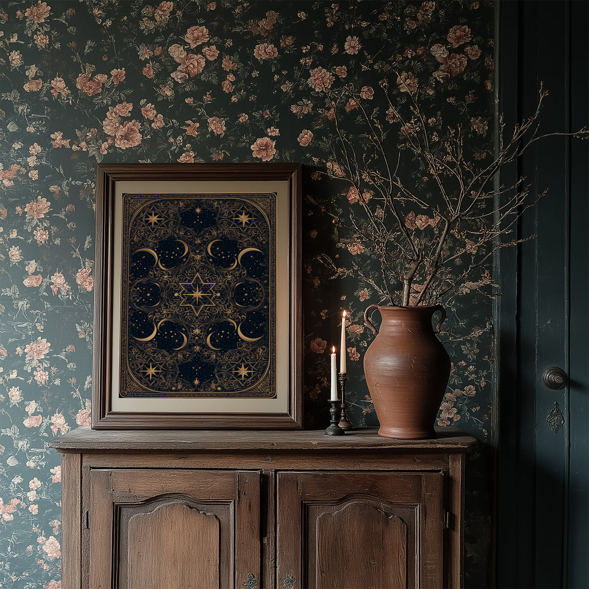 The Gilded Wheel of Midnight, a gold ornamental mandala of moon phases and stars on a deep navy field, painted in navy and antique gold, in a dark frame on a wooden dresser against floral wallpaper