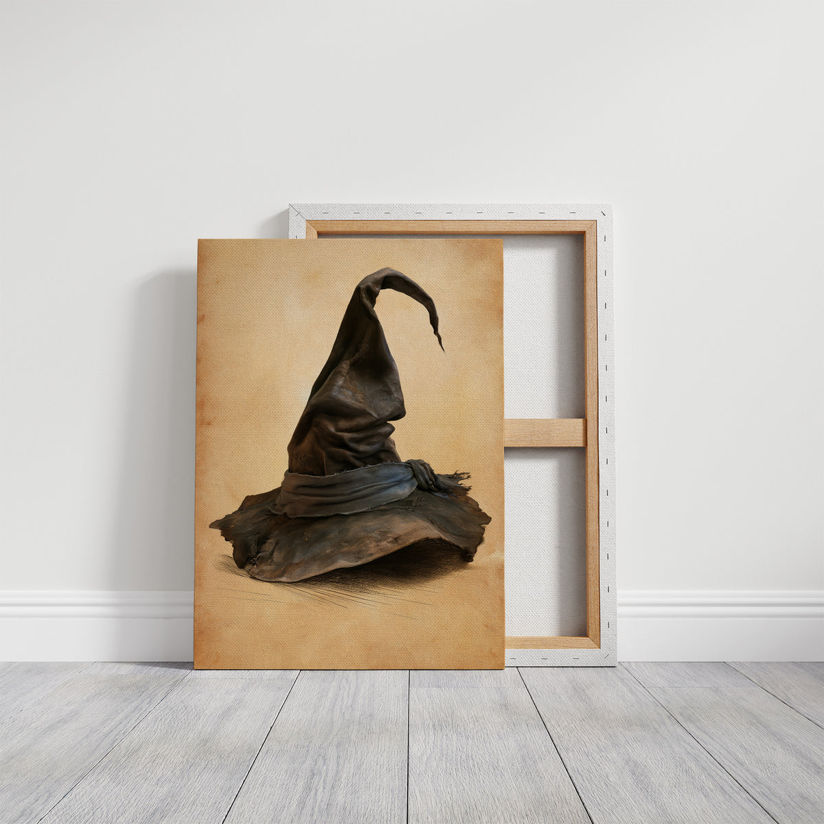 The Hat Left by the Door, a single pointed witch hat with a soft bend at the tip, sitting on a worn cream ground, painted in charcoal, brown and tan, on a gallery canvas with wrapped edges leaning against a white wall