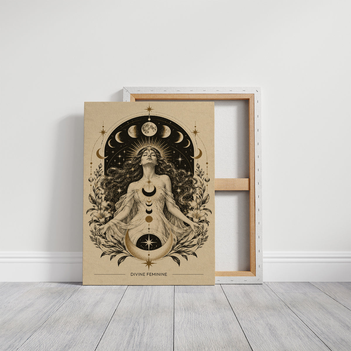The Moon Woven Into Her Hair, a seated woman in quiet meditation crowned with a ring of crescent moons and surrounded by fern fronds, drawn in cream, charcoal and sepia with a deep brown border and small text at the base, on a gallery canvas with wrapped edges leaning against a white wall