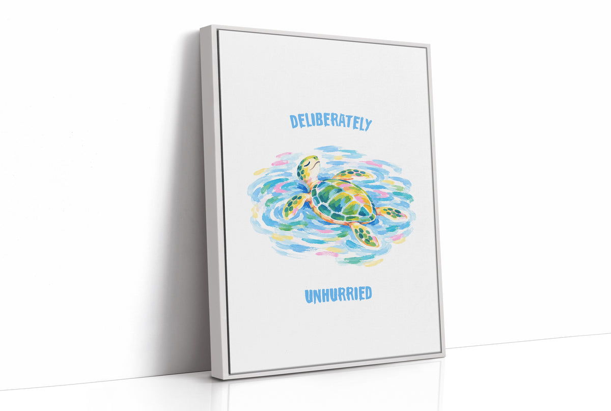 The Turtle Keeps Its Own Time, a sea turtle drifting over pale blue and green watercolor waves, with two lines of bold blue lettering above and below it on a white ground, in a soft watercolor style, as a framed canvas in a white frame