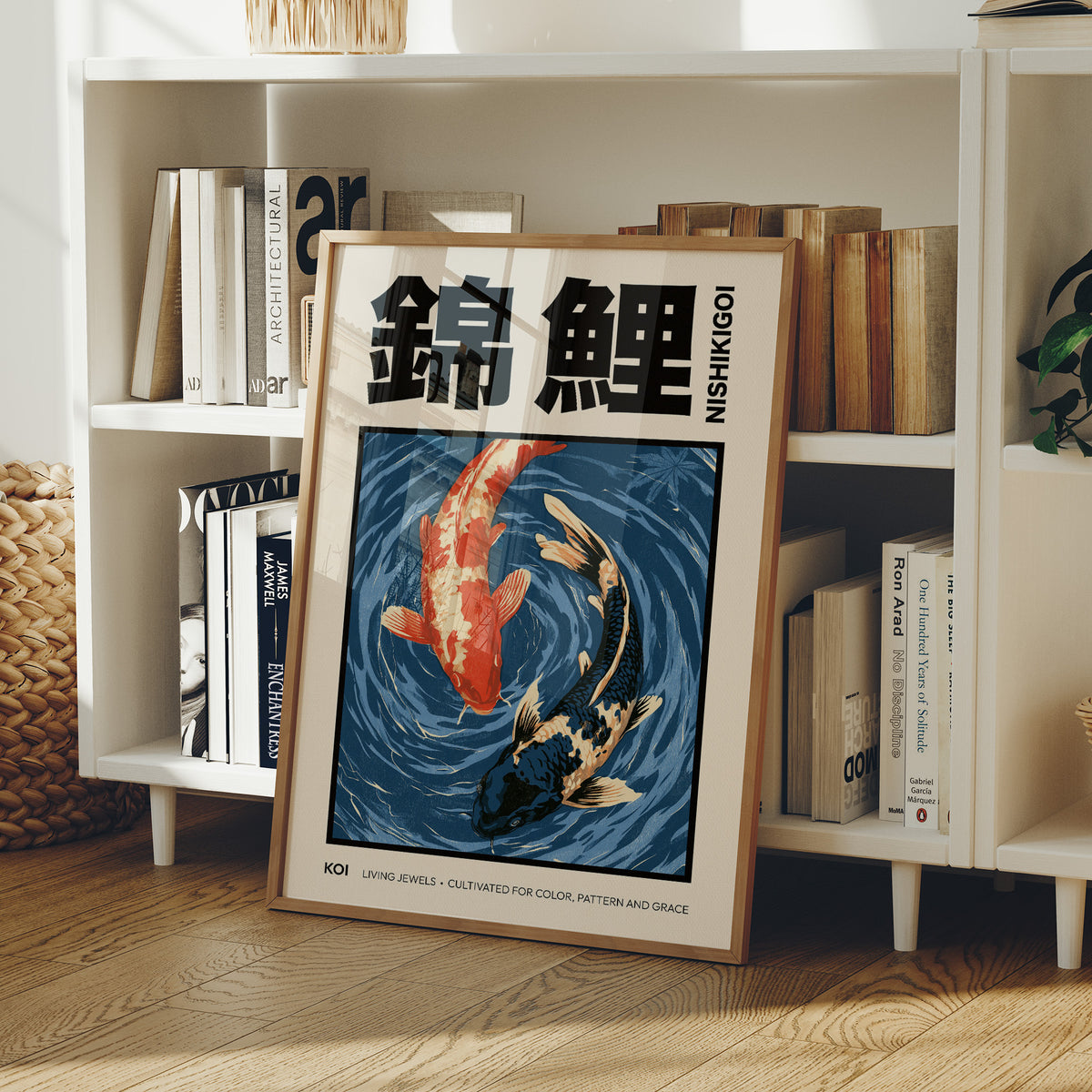 Two Fish Turn Beneath the Surface, two koi, one flame orange and one cream, turning through deep blue water with patient ripple lines, in a flat Japanese woodblock style, in a wood frame on a white bookshelf beside stacked books and a small basket