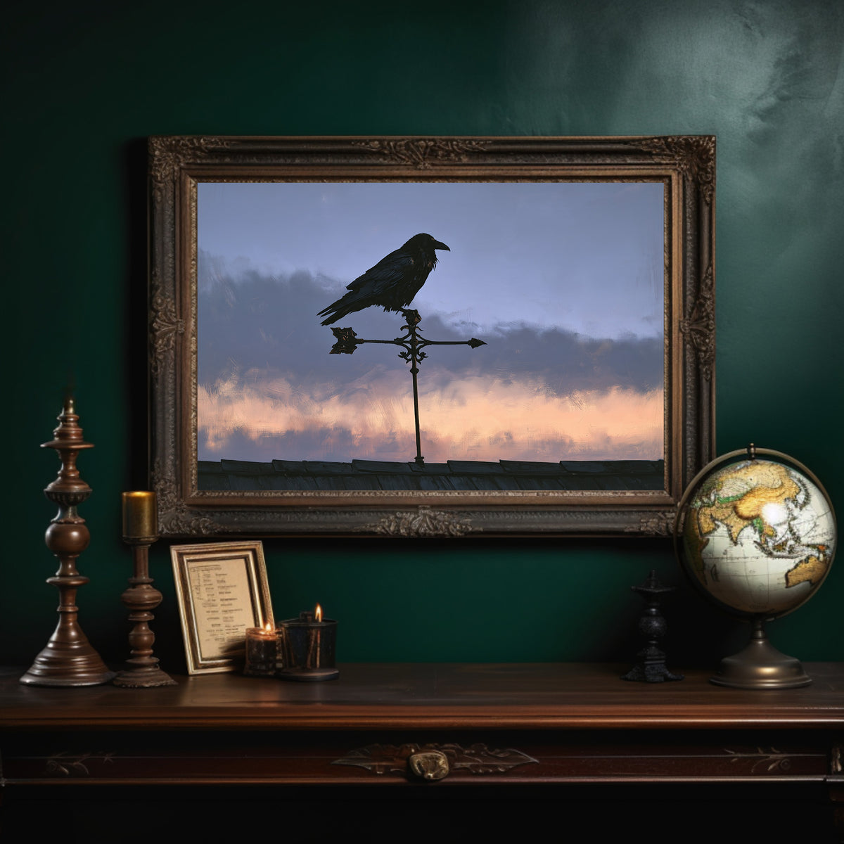 Watcher on the Weathervane, a black raven perched on a weathervane against a dusk sky banded in dusky blue and rose, in an ornate dark frame on a deep green wall above a mantel with a globe and candles