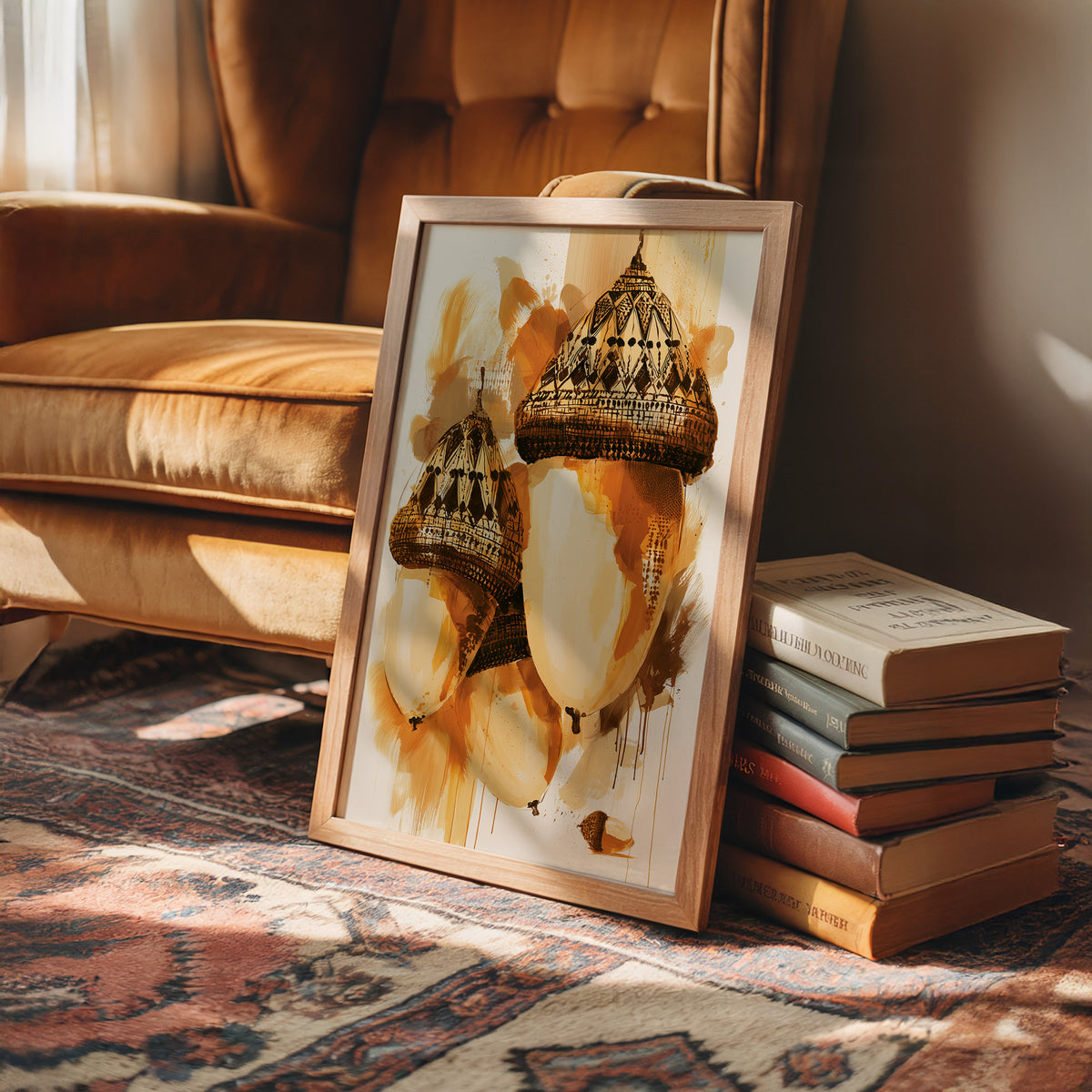 Where the Acorns Hold Their Amber, painterly oak nuts with carved caps and drips of ochre and cream on a pale ground, in a wood frame on a rug beside a leather armchair and a stack of books