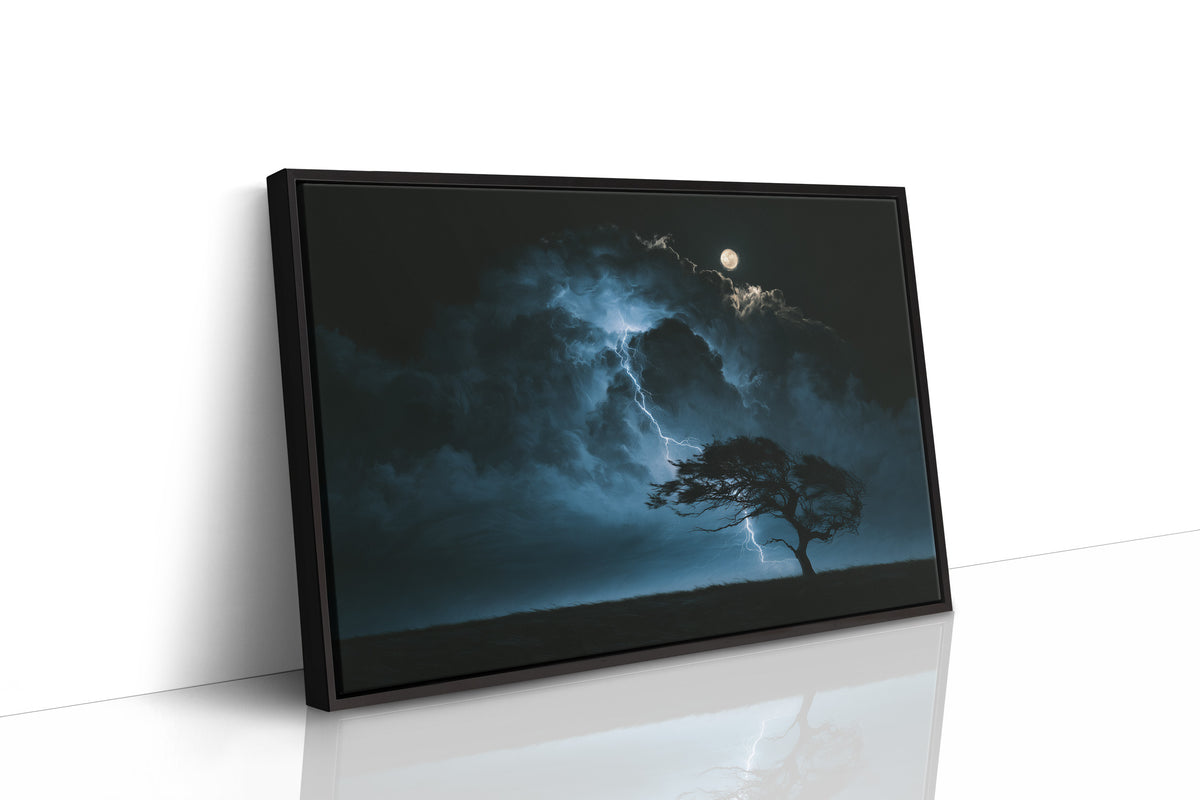 Where the Lightning Keeps Its Distance, lone tree silhouetted under a full moon in blue storm light painting, as a framed canvas in a black frame