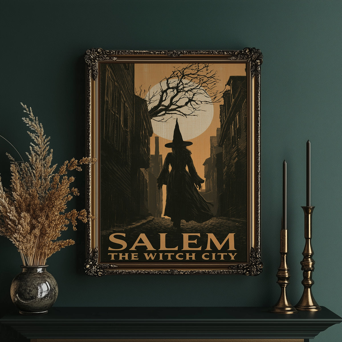 Witch City at Moonrise, a cloaked silhouette beneath a bare tree and a full moon on a vintage style travel poster, painted in amber, olive and black, in an ornate gold frame on a deep green wall beside brass candlesticks