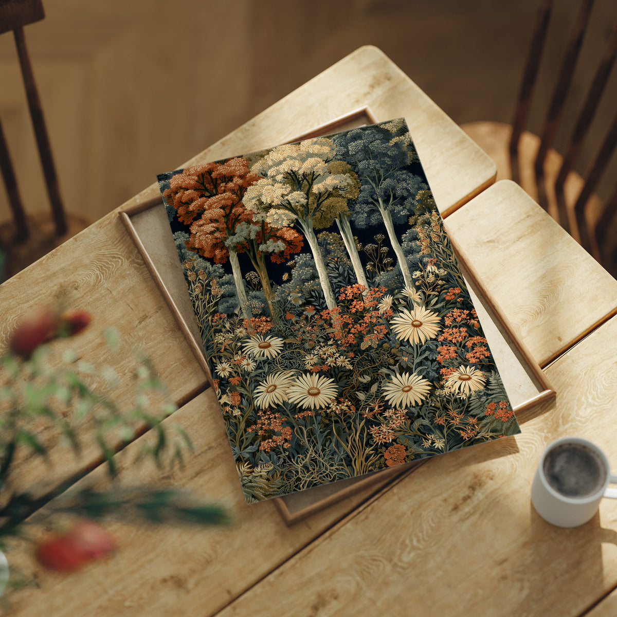 Daisy Chain Reaction In The Woods, print laid on a wooden table beside a white mug and flowers