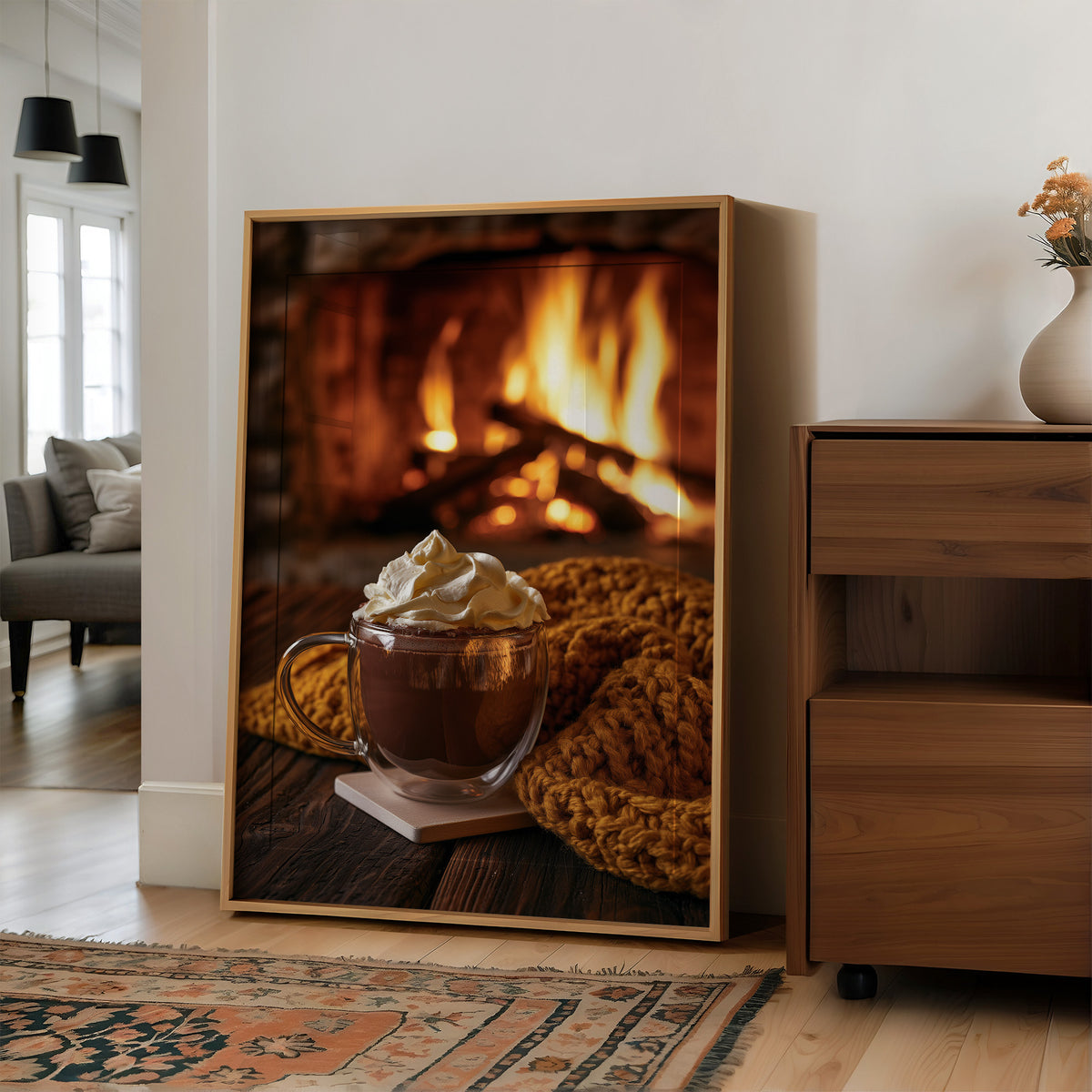 Cocoa Loco By The Fire, large framed print leaning on a white wall beside a wood cabinet