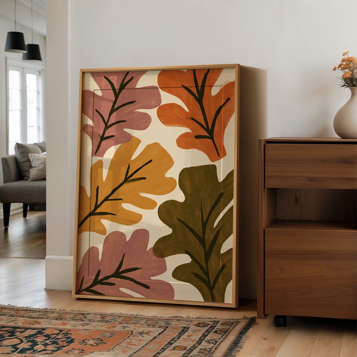 Big Leaf Energy, large framed print leaning on a white wall beside a wood cabinet