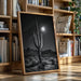 Framed desert landscape print on a wooden floor with bookshelves in the background