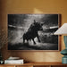 Framed black and white bull artwork on a wall above a wooden cabinet with decorative items.