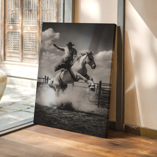 Canvas print of a cowboy on a horse leaping over a fence in a room with a wooden floor and glass door.
