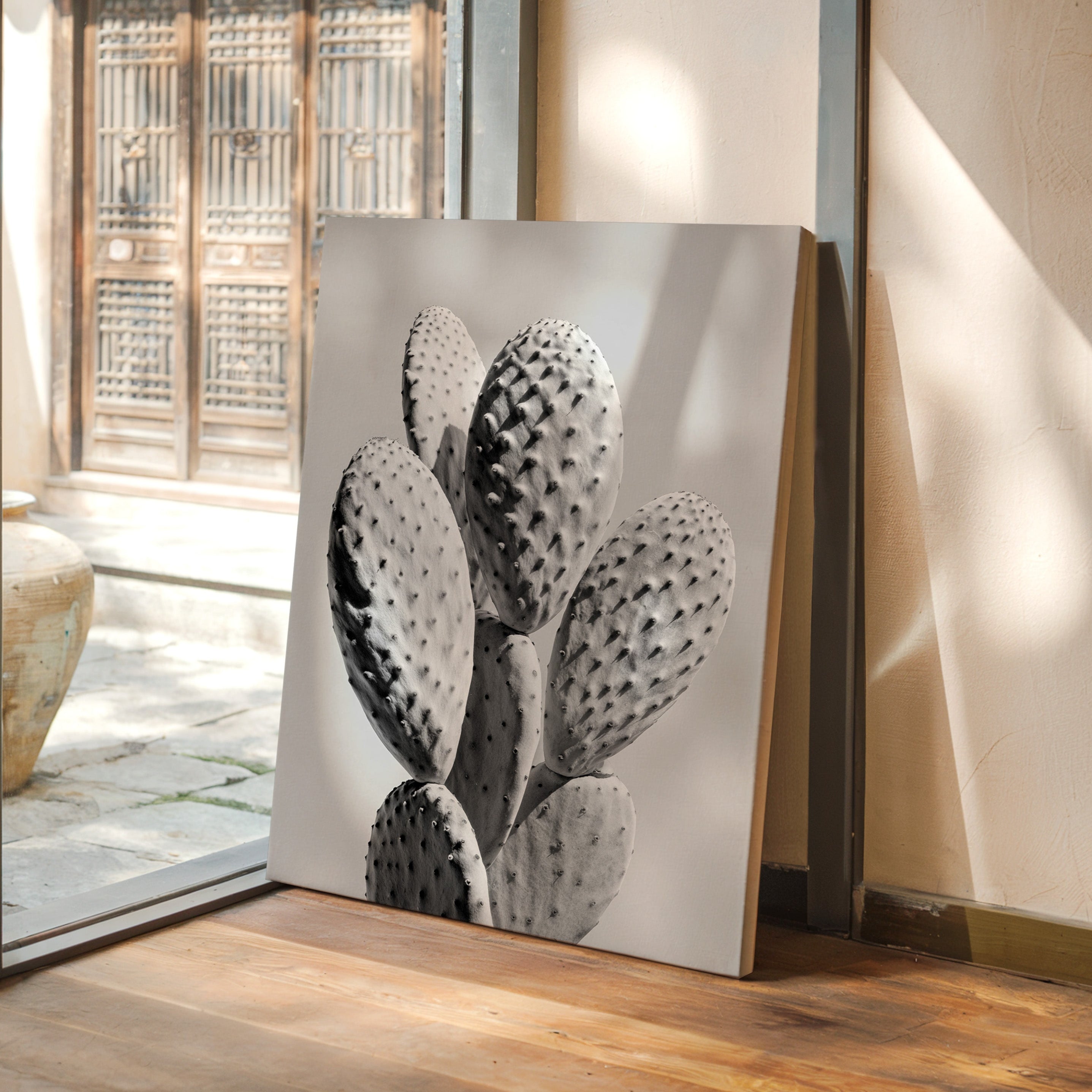 Decorative painting of a cactus on a wooden floor with a glass door in the background