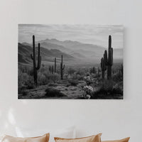 Bedroom with a large wall art print of a desert landscape featuring cacti.