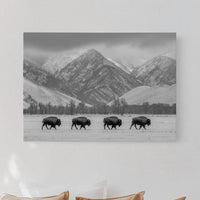Bedroom with a mountain landscape print above a bed with beige pillows.