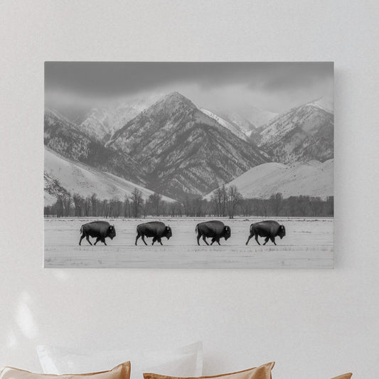 Bedroom with a mountain landscape print above a bed with beige pillows.