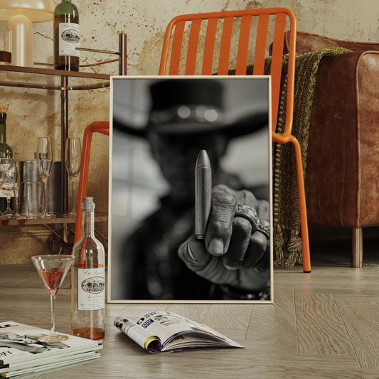 Living room with a brown leather sofa, orange chair, and a framed picture on the floor.