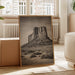 Room interior with a large framed picture of a desert landscape, plants, and furniture.