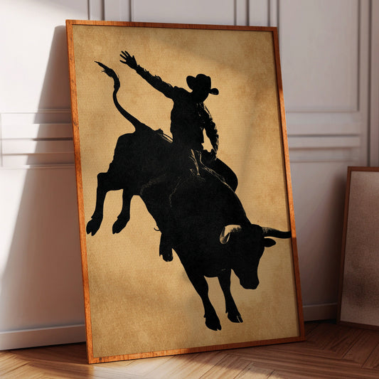 Framed artwork of a silhouette of a cowboy riding a bull on a wall.