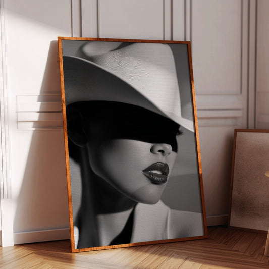 Framed black and white portrait of a woman with a hat on a wooden floor.