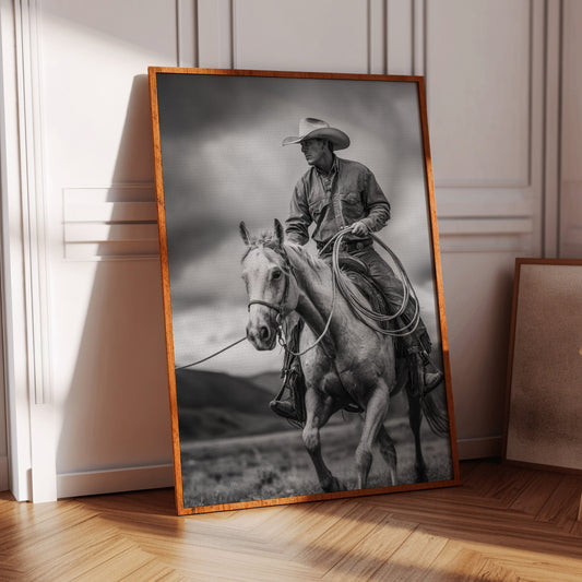 Framed black and white photograph of a cowboy on horseback in a room with wooden floor and chair.