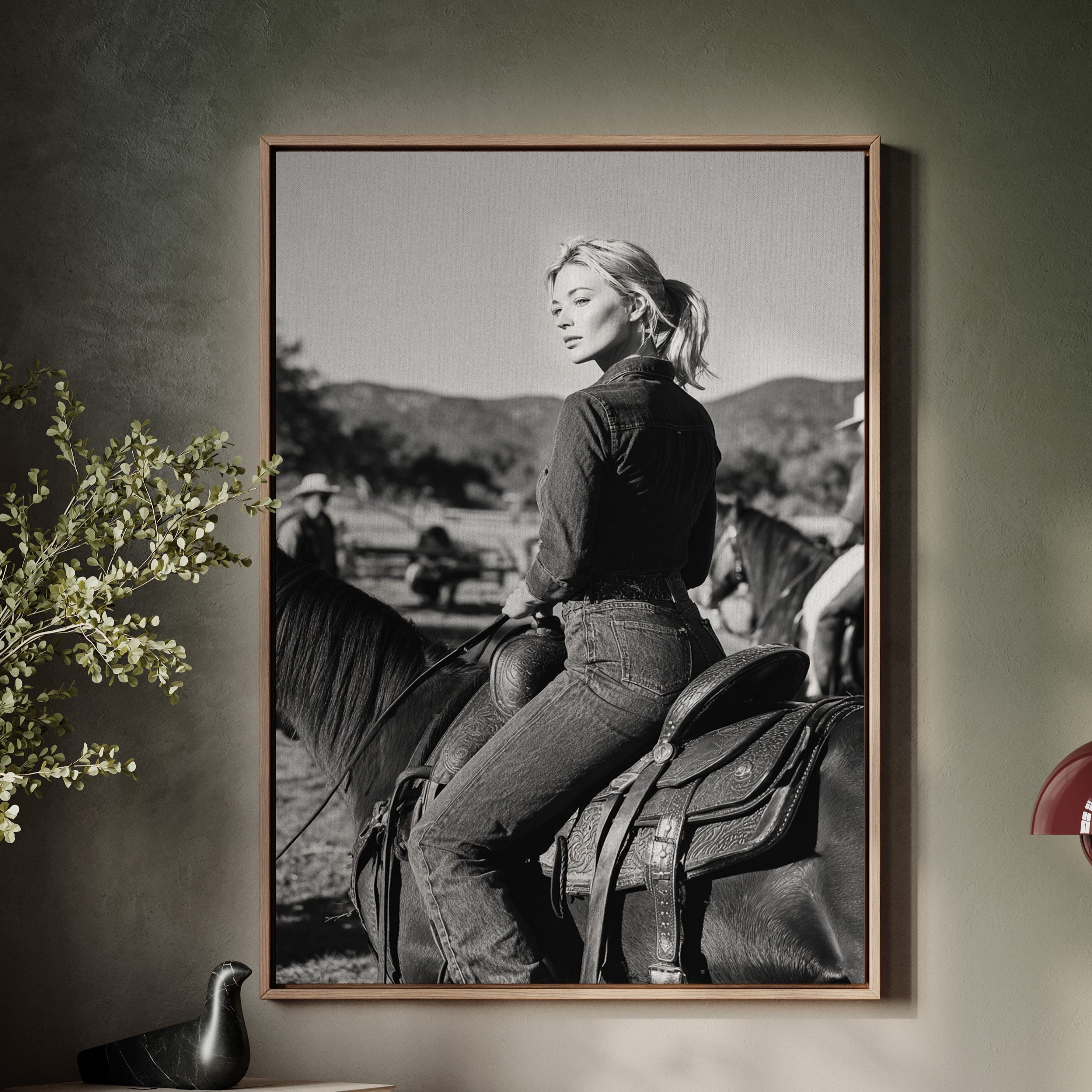 Framed black and white photograph of a woman on a horse above a wooden console table.