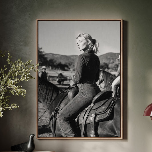 Framed black and white photograph of a woman on a horse above a wooden console table.