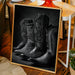 Framed photograph of cowboy boots on a wooden floor with a chair and plants in the background.