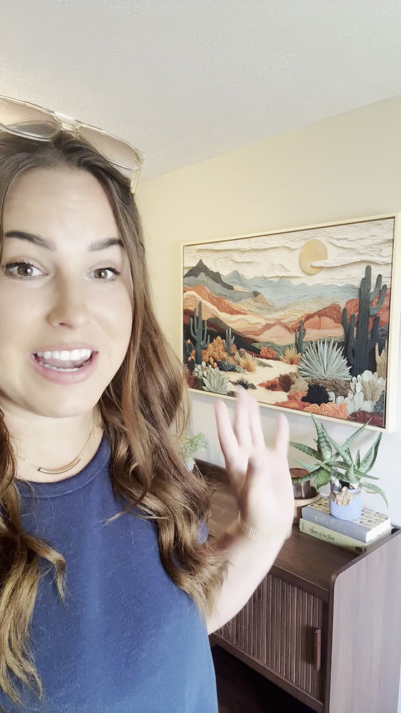 Christi showing her framed Kooly desert landscape