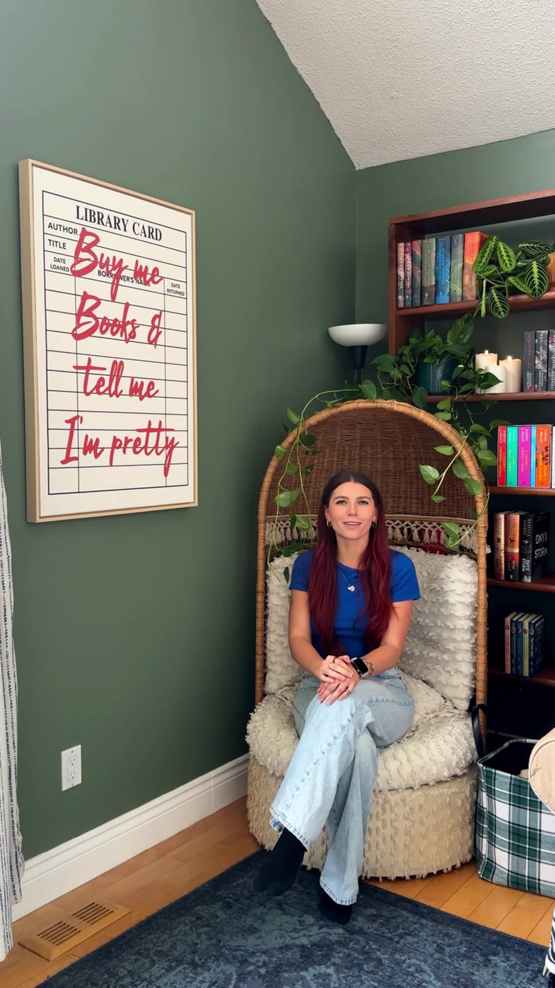 Meghan in her reading nook with her Kooly library card print