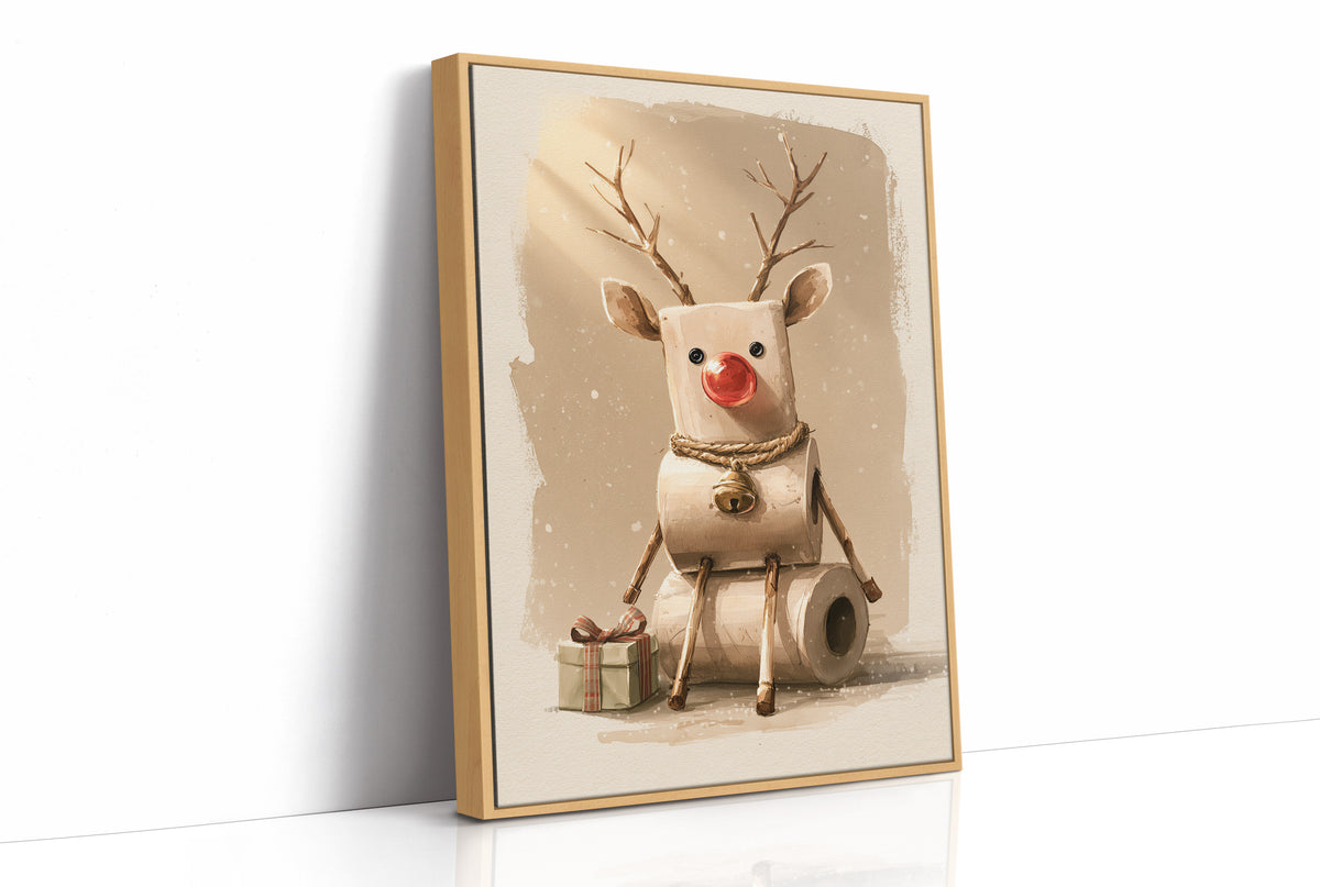 A Reindeer Takes a Seat, a cream reindeer with a red nose and small antlers seated on a stack of rolled tissue, with wrapped gift boxes at its feet, painted in cream, tan and soft red, as a framed canvas in a natural wood frame