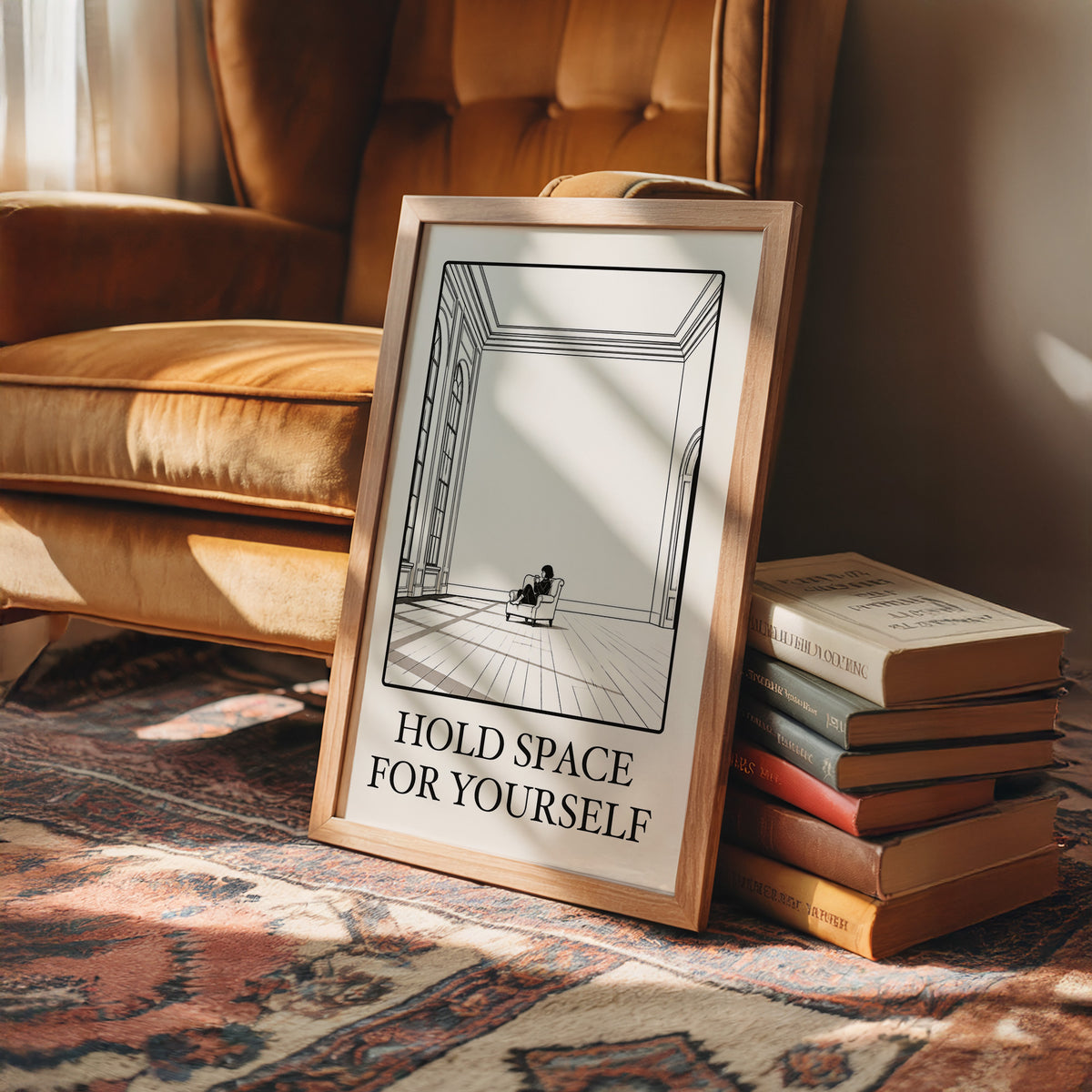 A Room Kept Open for You, a fine black line drawing of a tall empty room with a long floor, a pale window and a small seated figure, with the serif words HOLD SPACE and FOR YOURSELF beneath it on a cream ground, in a wood frame on a rug beside a leather armchair and a stack of books