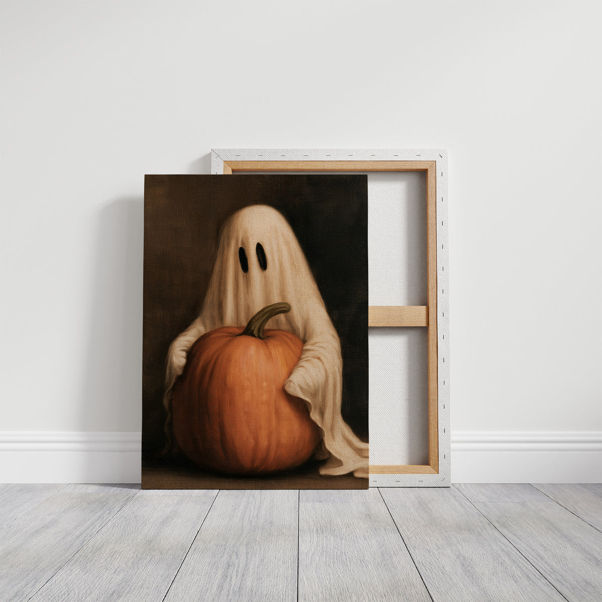 A Sheet Holds the Pumpkin Still, a pale draped figure holding a large orange pumpkin close, in a dark brown painted frame with a warm glow, on a gallery canvas with wrapped edges leaning against a white wall