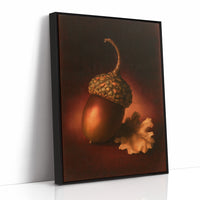 A Single Acorn in Candlelight, one acorn resting beside a curled oak leaf on a dark brown ground, lit from one side and painted in chestnut, amber and deep shadow, as a framed canvas in a black frame